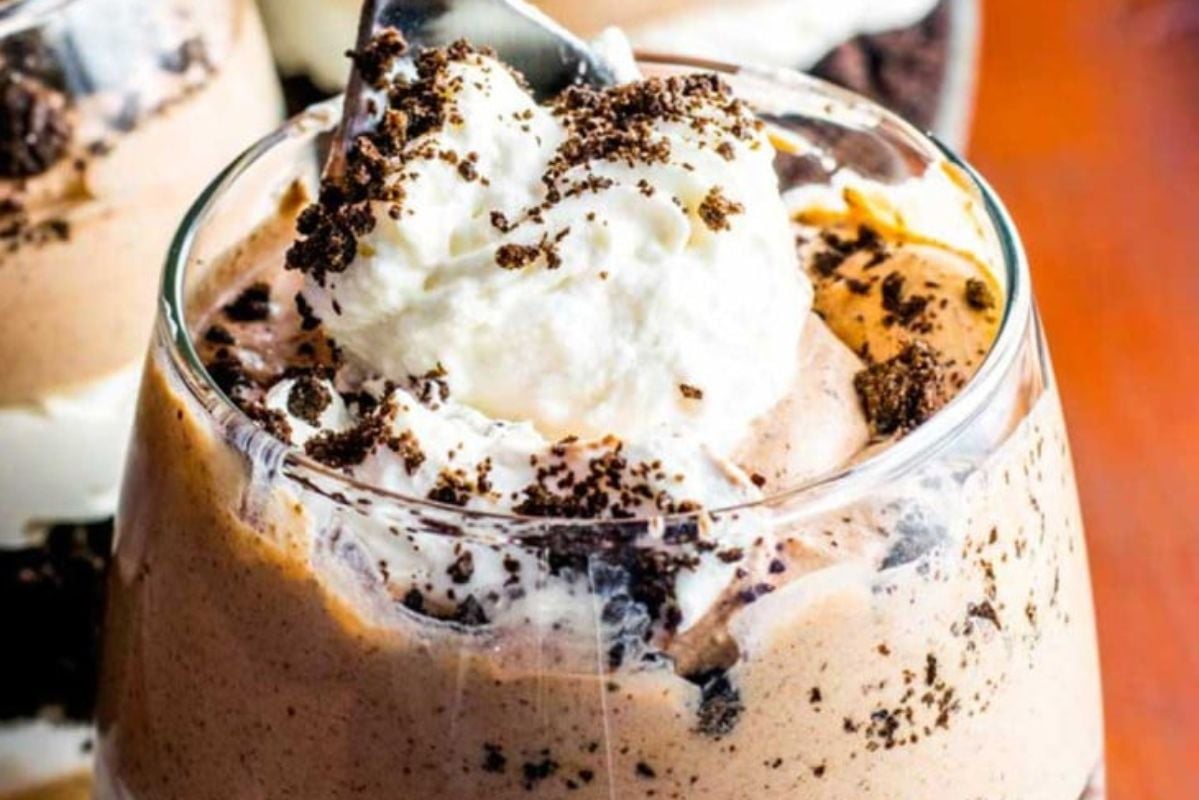 A single-serve glass of chocolate mousse topped with whipped cream and chocolate cookie crumbles—perfect for lovers of individual desserts.