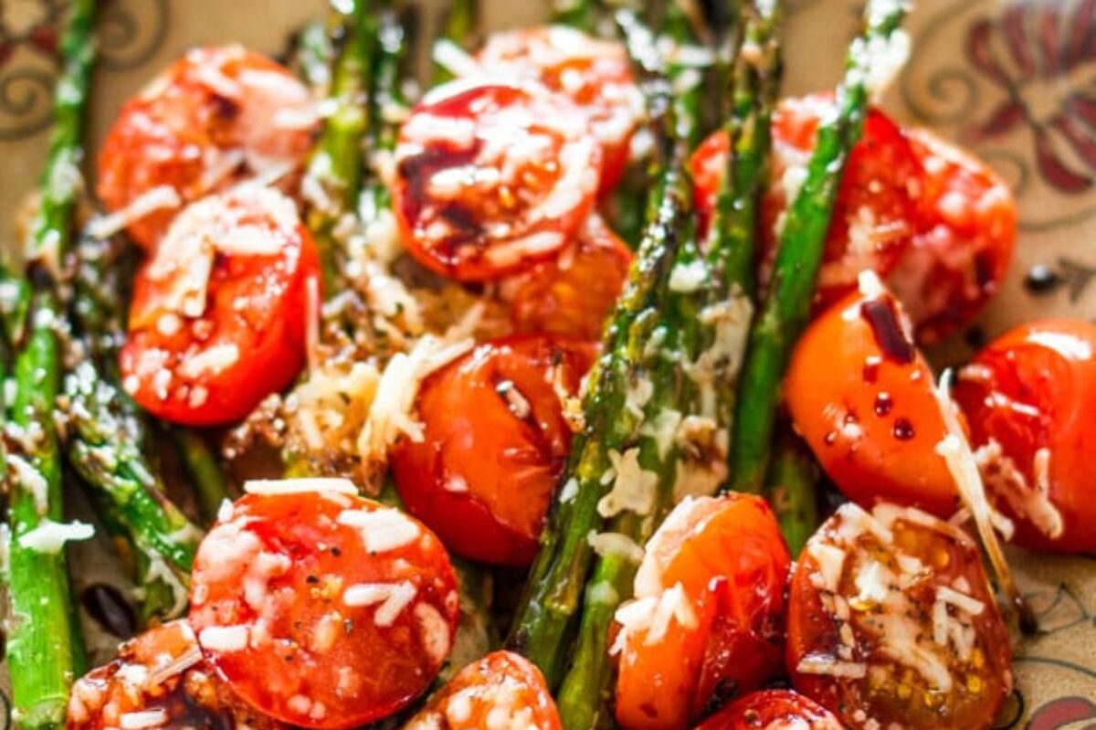 Grilled asparagus and cherry tomatoes topped with grated cheese and seasoning, perfect for Easter sides.