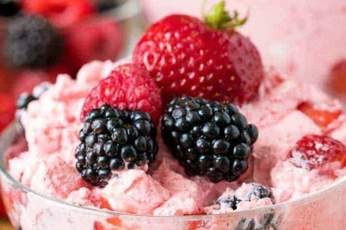 A bowl filled with berries, ice cream, and jello salads.