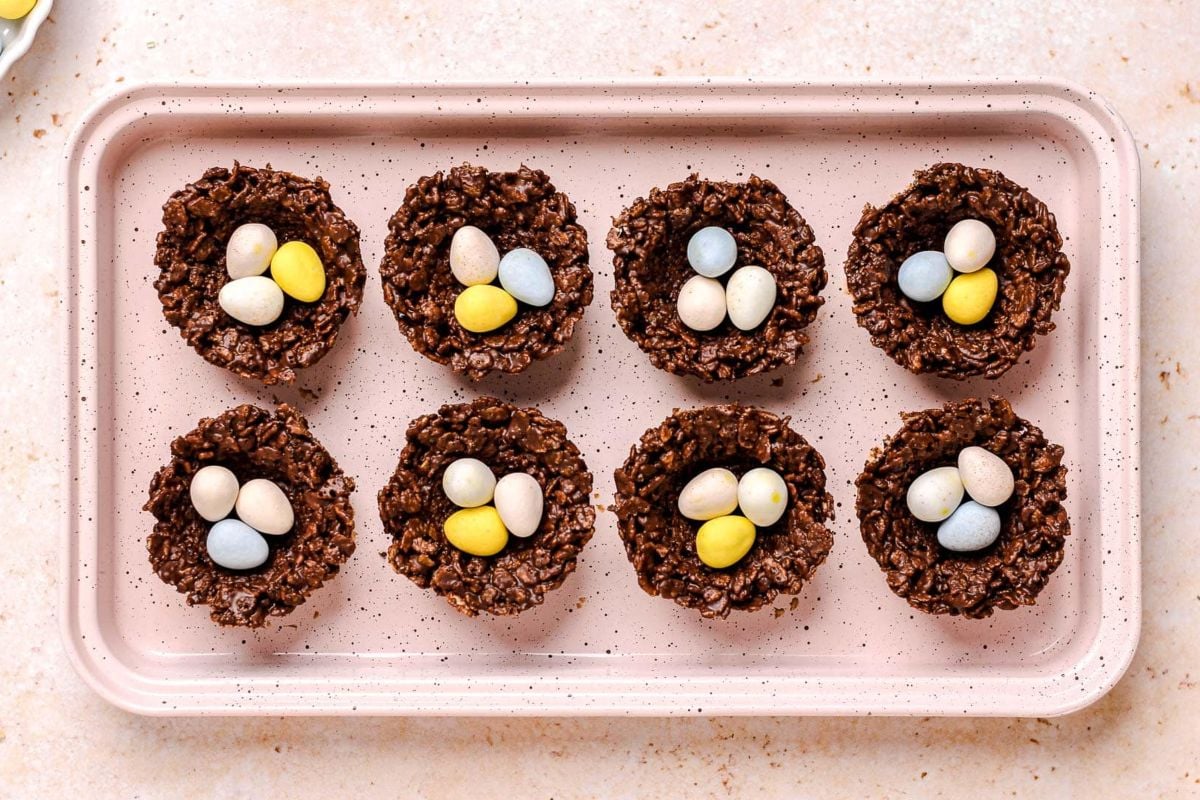 Tray of Easter chocolate rice cereal nests filled with candy-coated eggs.