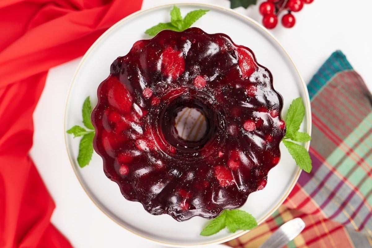 A cranberry jelly doughnut on a plate, reminiscent of jello salads.