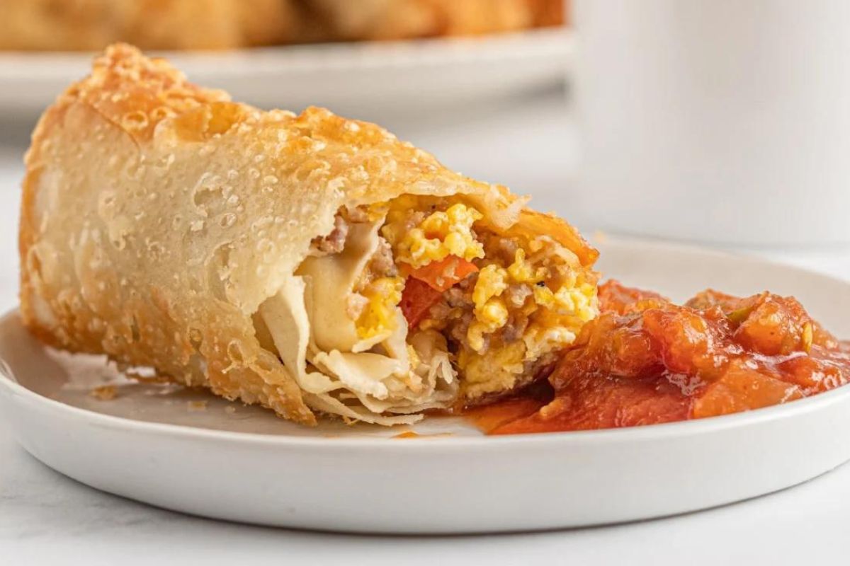 A plate with a breakfast egg roll from egg recipes on it.