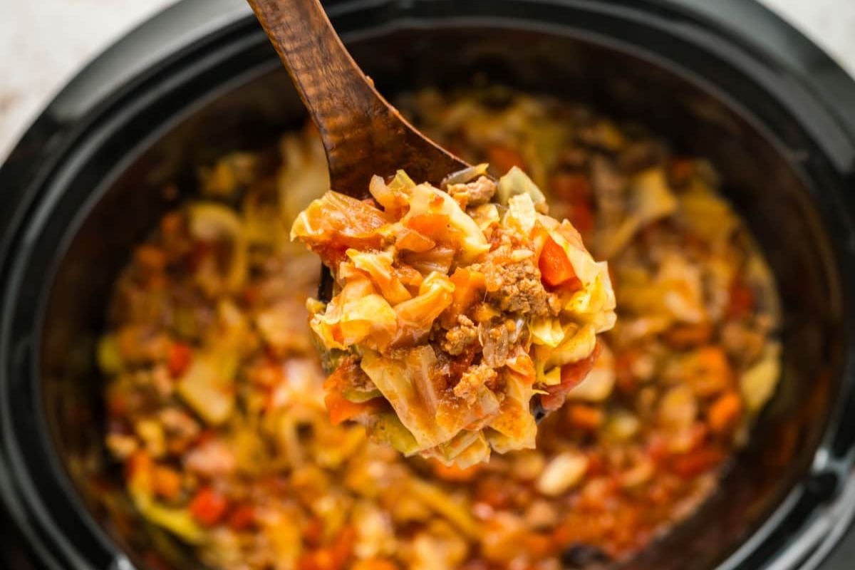 A spoonful of cabbage soup recipes in a crock pot.
