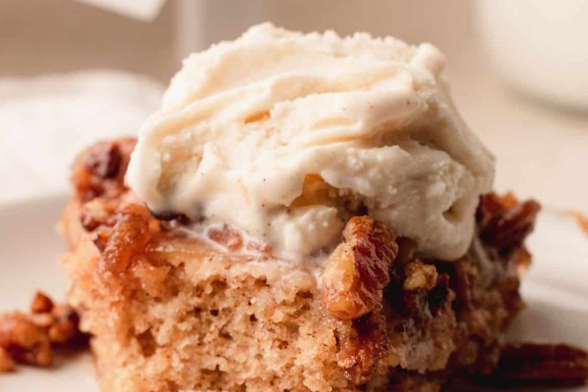 A slice of cinnamon cake, inspired by classic upside down cakes, topped with vanilla ice cream and chopped pecans.