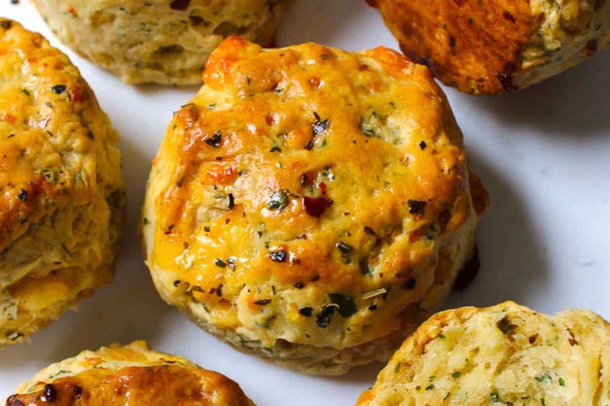 Golden, flaky savory biscuits with herbs and cheese make perfect Easter sides, displayed beautifully on a white surface.