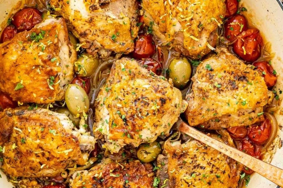 Easter dinner: Roasted chicken thighs with herbs and cherry tomatoes in a cooking pan.