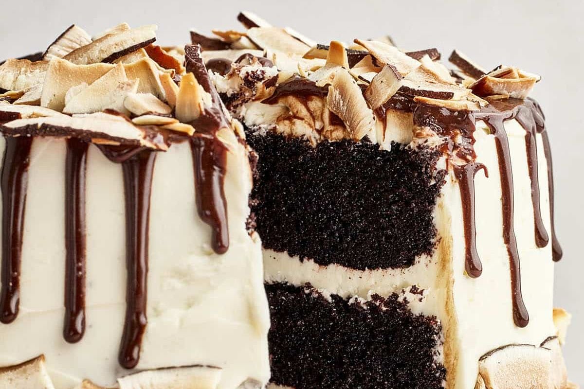 An Easter sliced chocolate layer cake with vanilla frosting and chocolate drizzle.