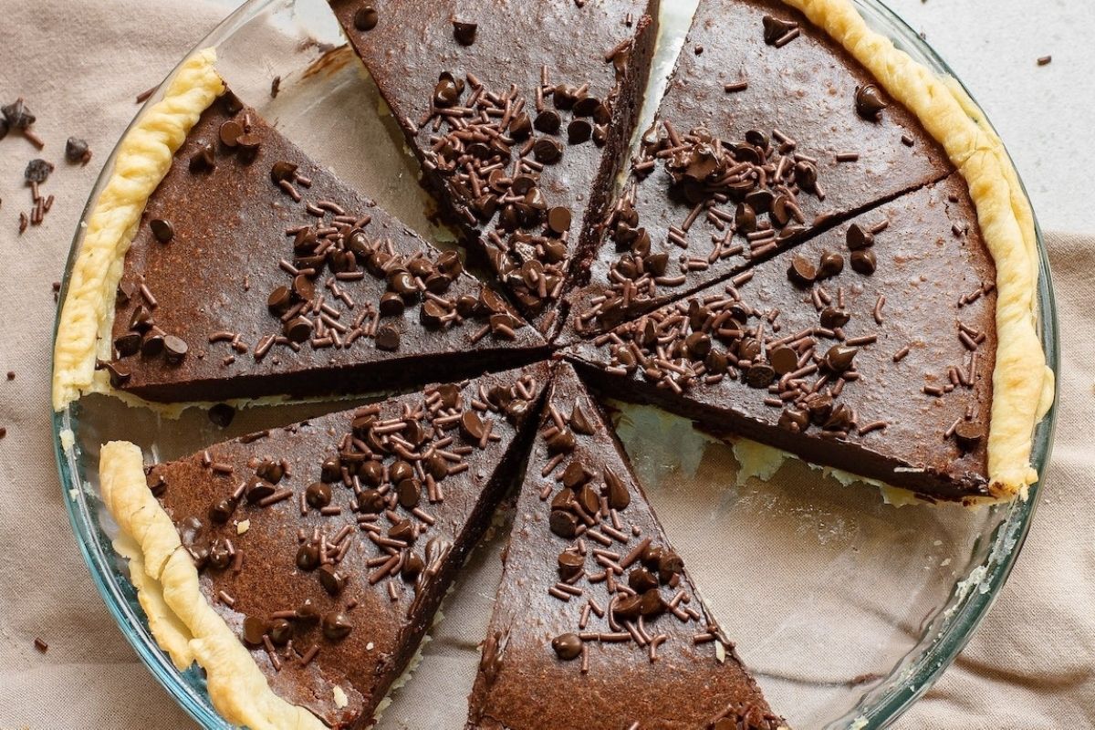 A pie with chocolate toppings on it, perfect for potluck desserts.