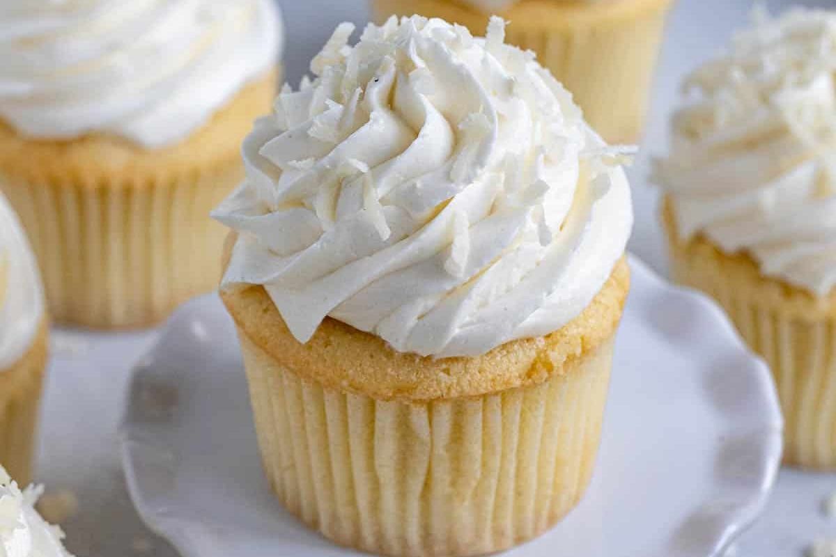Easter vanilla cupcakes topped with white frosting and coconut flakes.