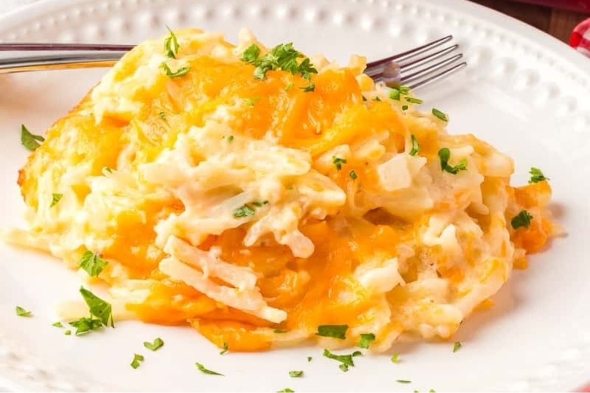 A plate of cheesy food with a fork.