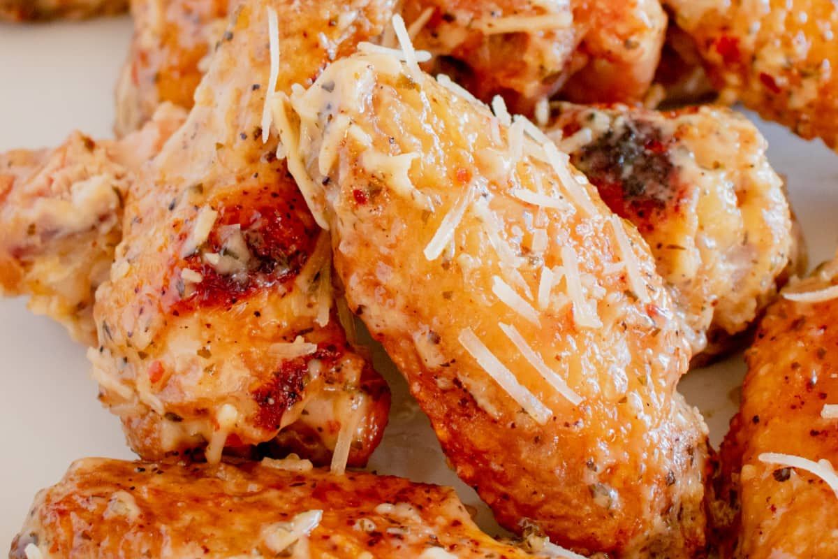 Seasoned chicken wings garnished with grated cheese.