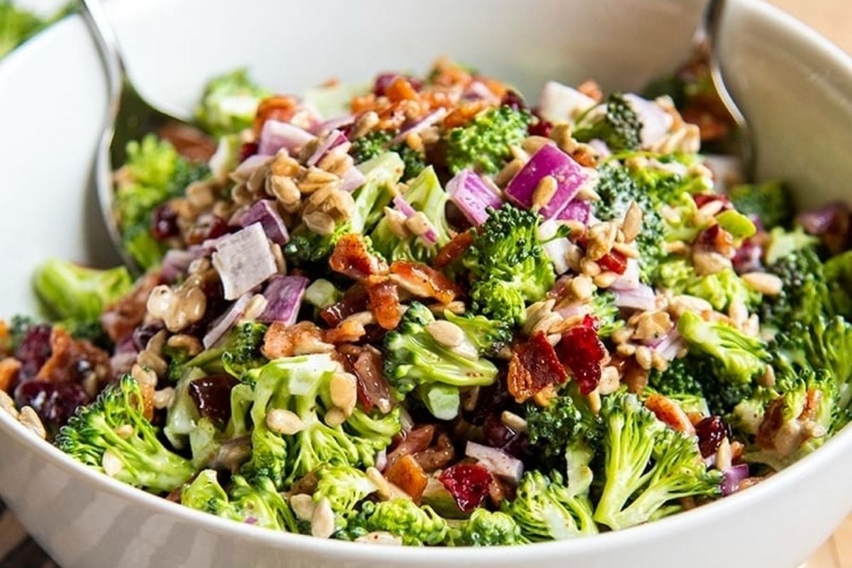 A bowl of broccoli salad with bacon and nuts, perfect for potluck sides.