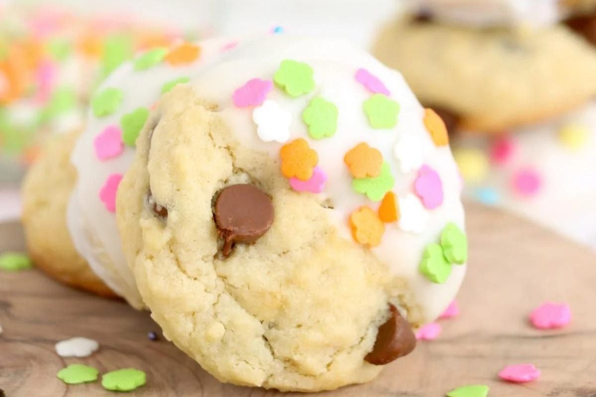 A chocolate chip cookie recipe topped with white icing and colorful sprinkles.