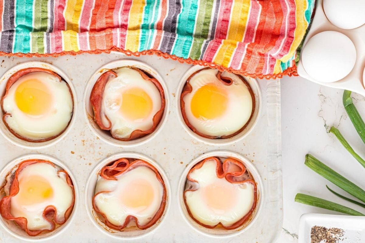 Baked eggs in ham cups served with ingredients on the side for Father's Day breakfast.