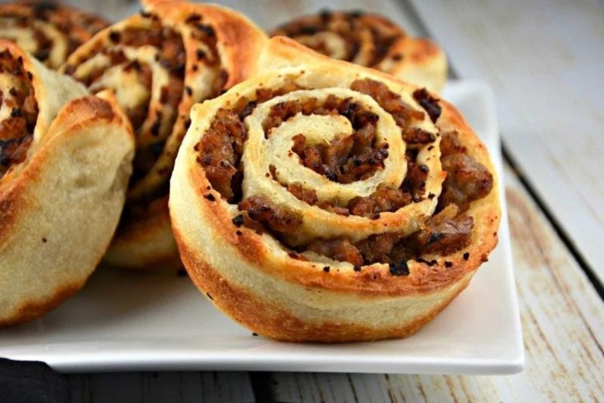 Freshly baked pinwheel pastries with a savory filling on a white plate for Father's Day breakfast.