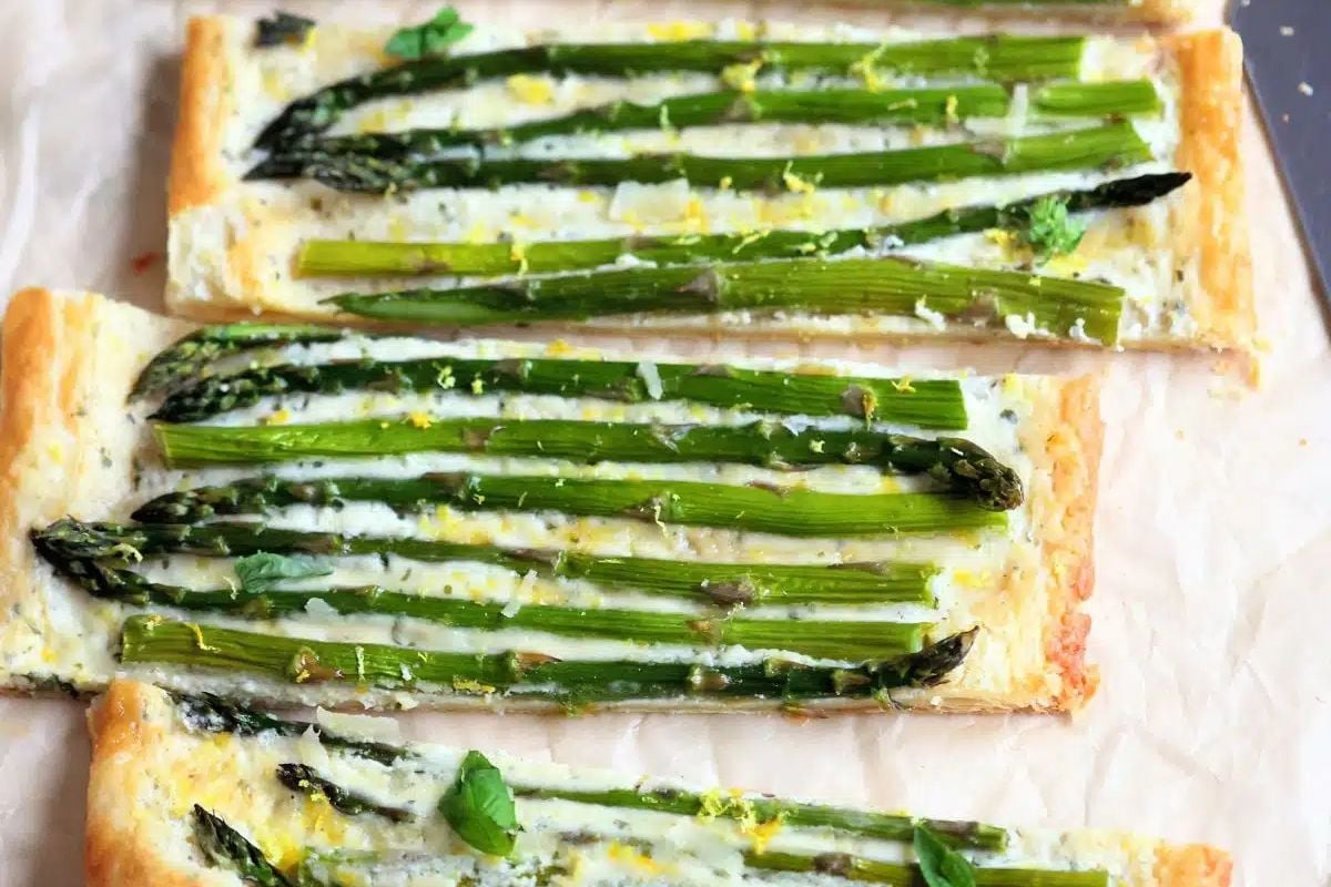Two asparagus tarts on parchment paper, perfect for an Easter appetizer.