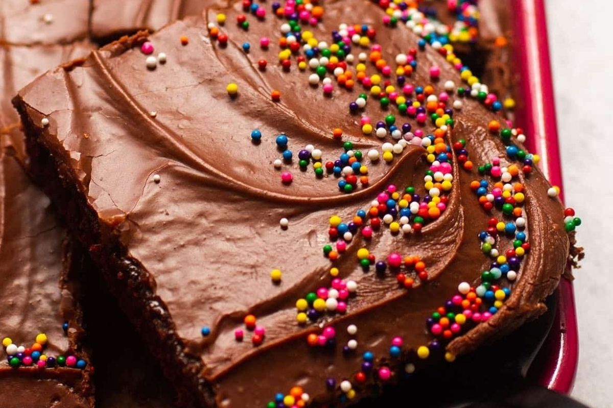 A slice of chocolate cake with sprinkles on top, perfect for potluck desserts.