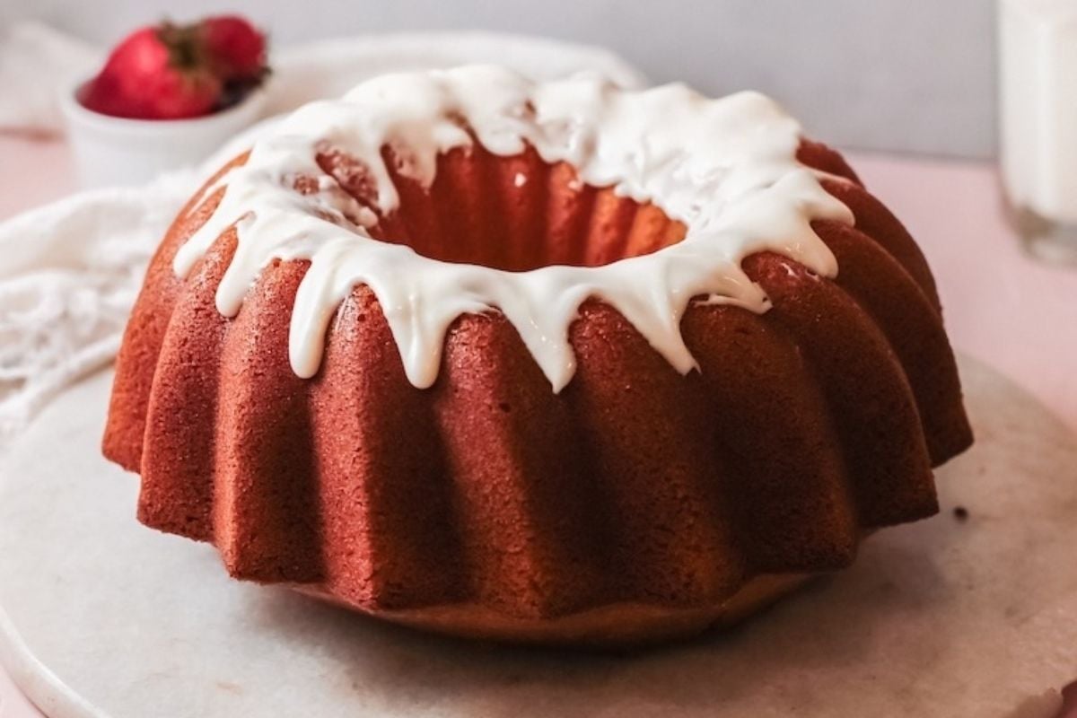 A potluck dessert featuring a cake with white frosting on top.