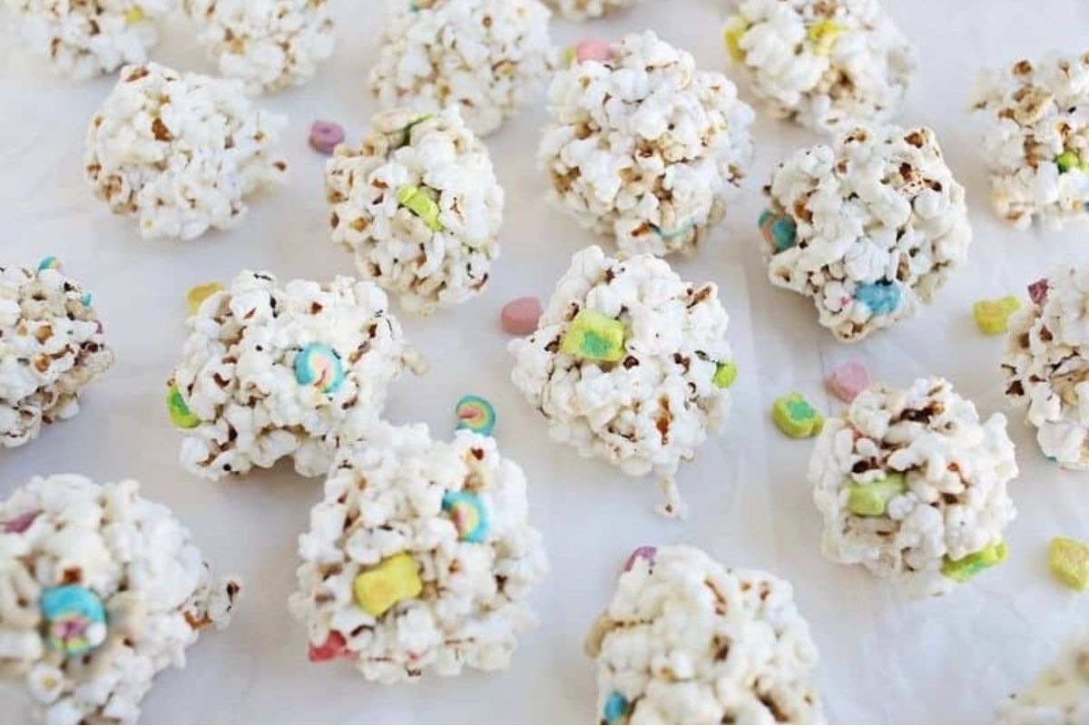 Easter popcorn balls with Lucky Charms on a white surface.
