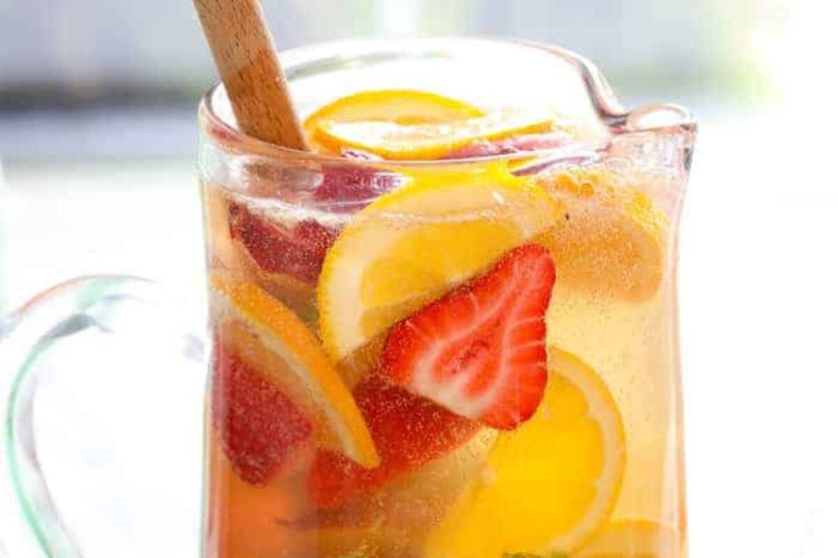 A pitcher of Easter iced tea with slices of lemon and strawberries.