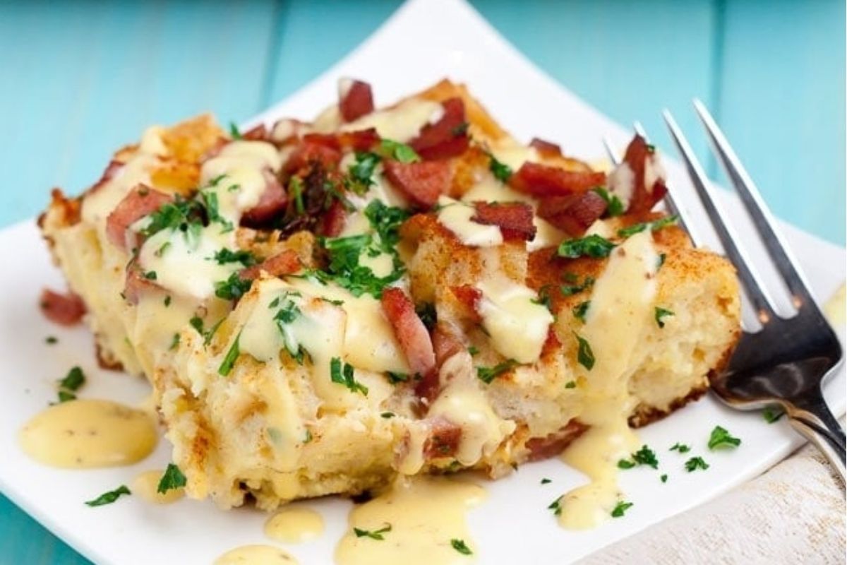 French toast casserole with bacon and cheese on a white plate.