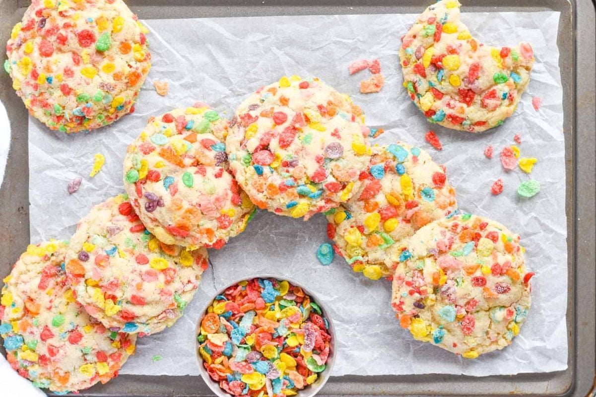 Colorful Easter cereal cookies on a baking sheet with parchment paper.