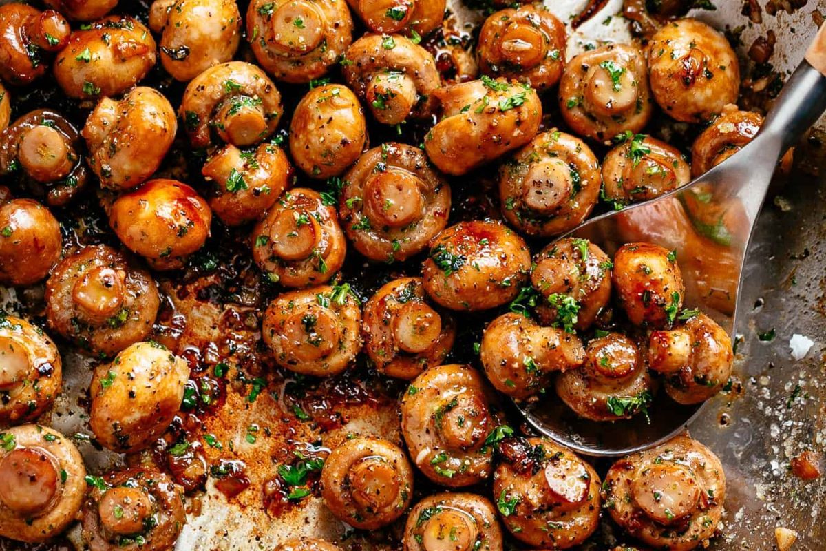 Glazed and seasoned mushrooms garnished with herbs in a cooking pan for Easter dinner.