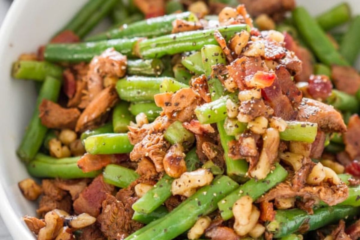 A bowl of green bean salad with bacon, nuts, and seasonings, perfect for Easter sides.