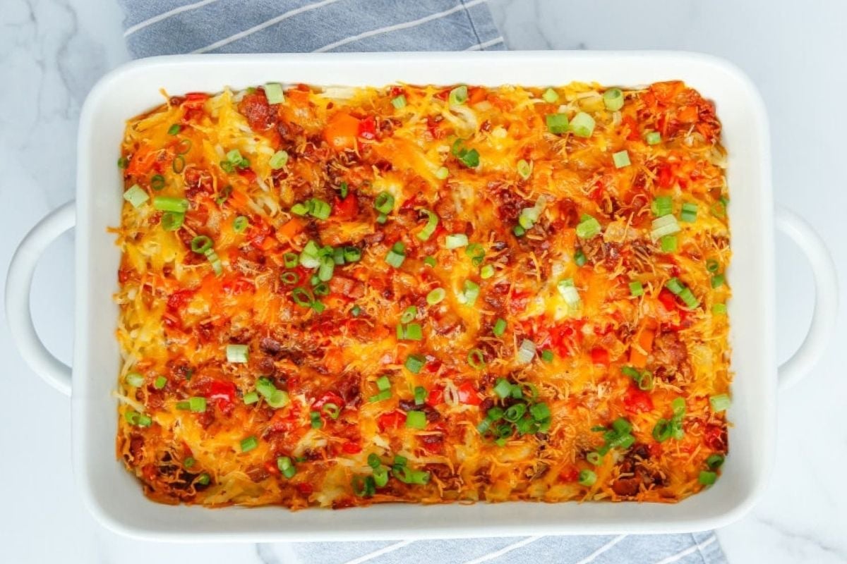 Father's Day breakfast casserole with melted cheese and chopped green onions on top.