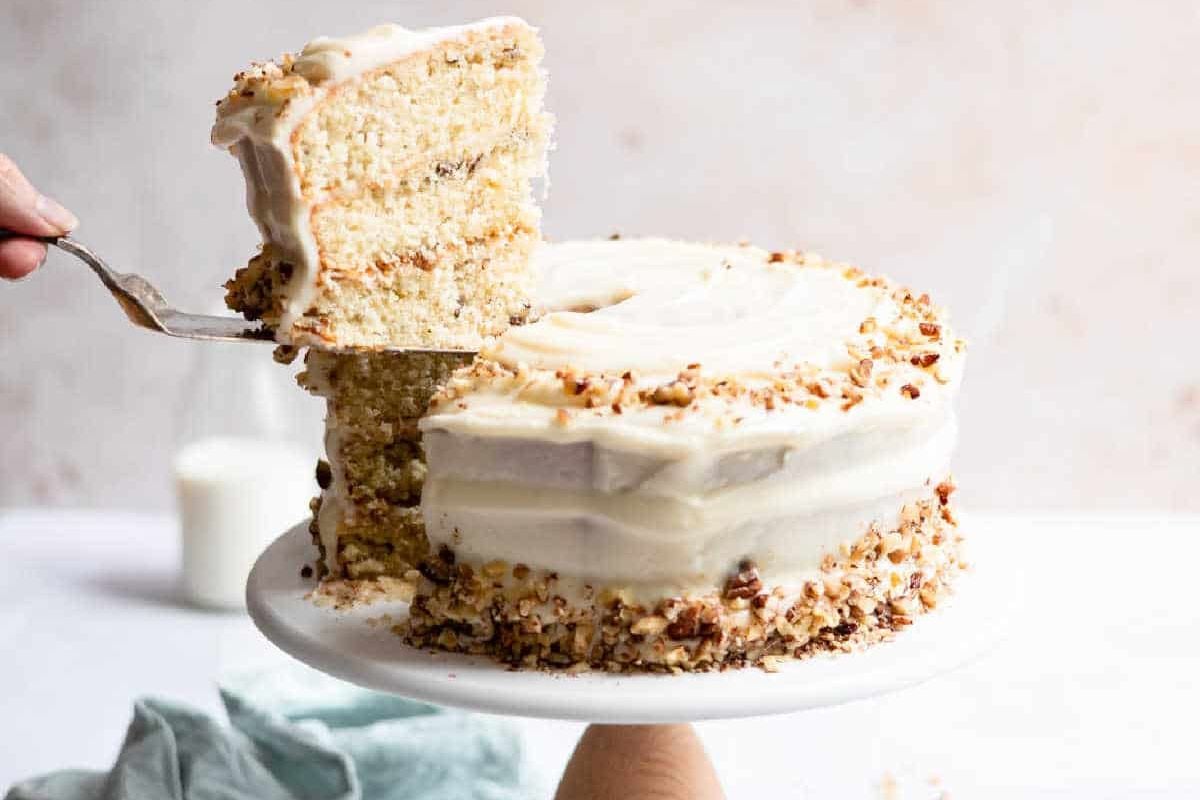 A slice of frosted layer cakes being served.