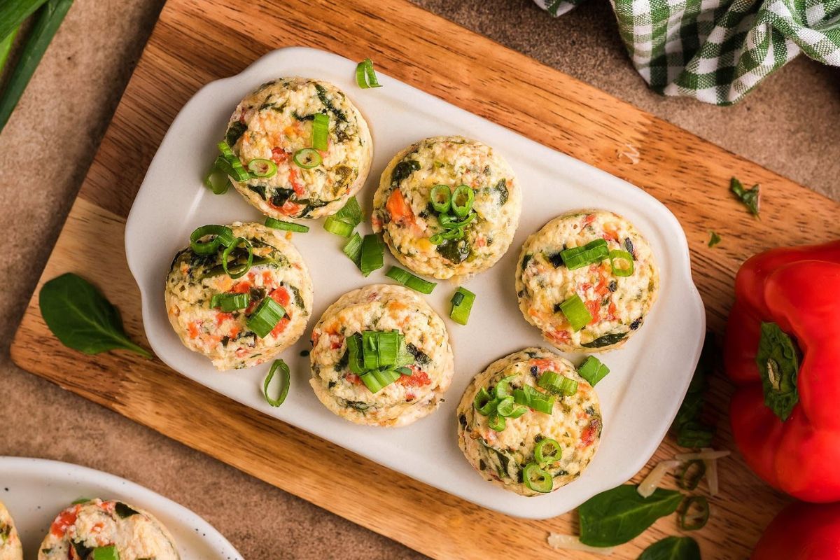 Stuffed mushrooms with egg recipes on a wooden cutting board.