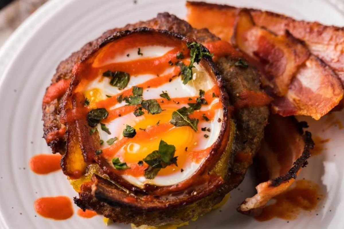 A plate with egg recipes and bacon on it.