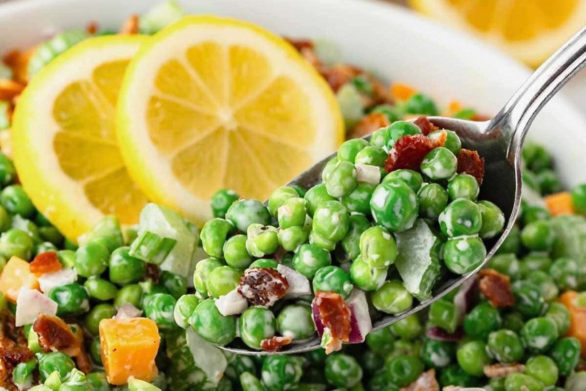 An Easter sides colorful pea salad with bacon bits and lemon slices.