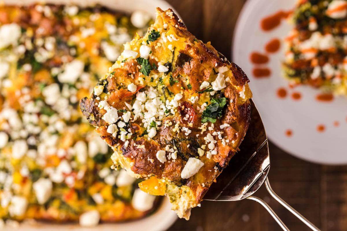 A piece of quiche made from egg recipes with spinach and cheese on a plate.