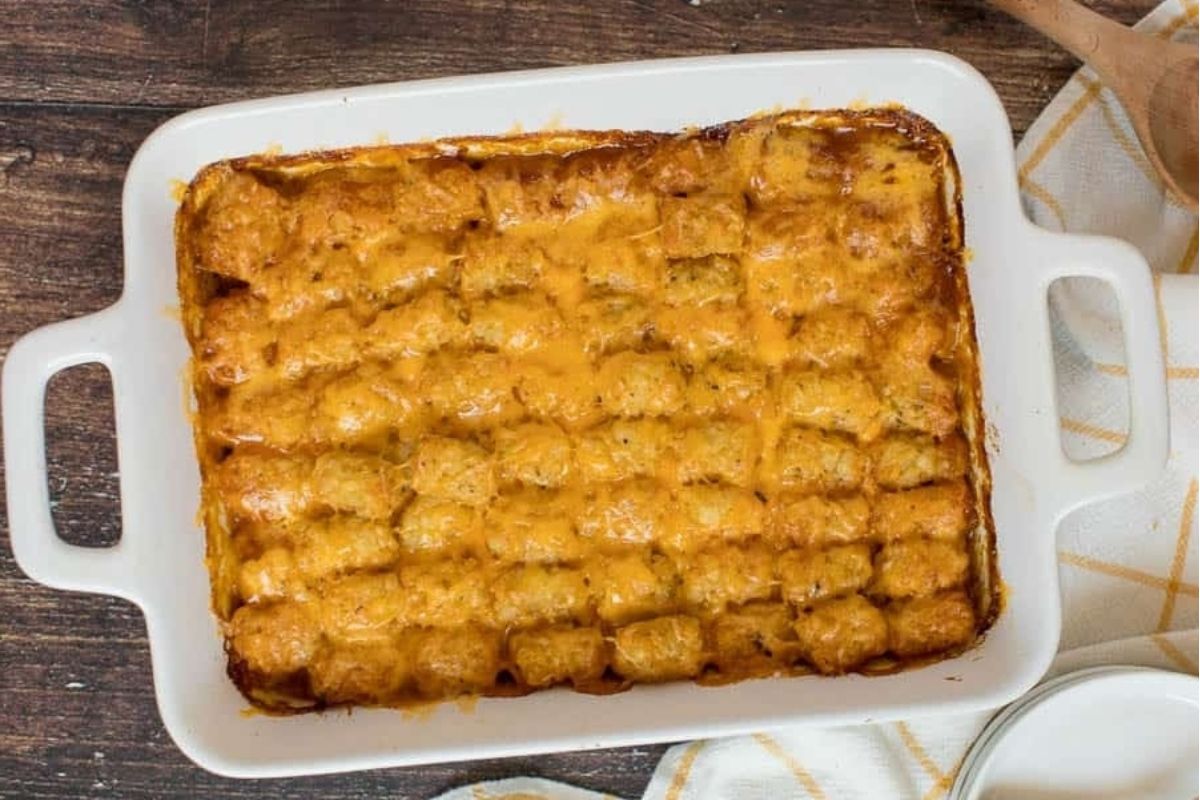 Cheesy tater tot spring casserole in a white dish.