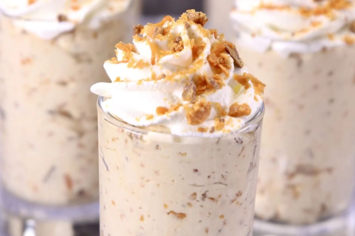 Easter desserts: Parfaits topped with whipped cream and crumbled cookies in clear glasses.