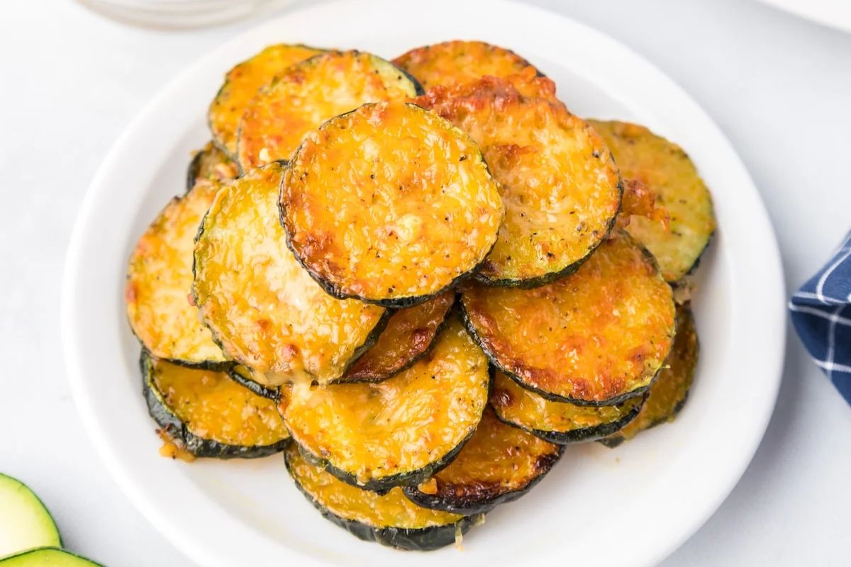 An Easter appetizer of a stack of baked parmesan-topped zucchini slices on a white plate.