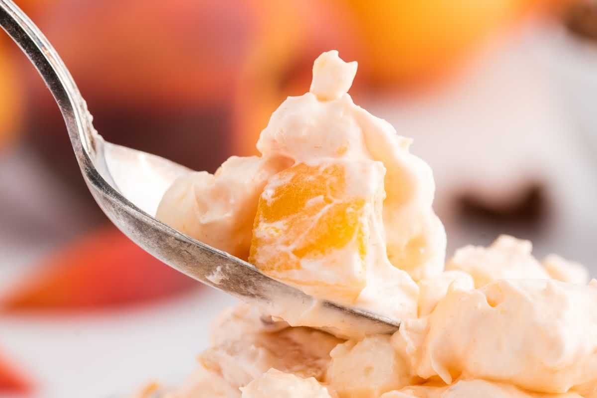 Close-up of a spoonful of Easter sides fruit salad with creamy dressing.