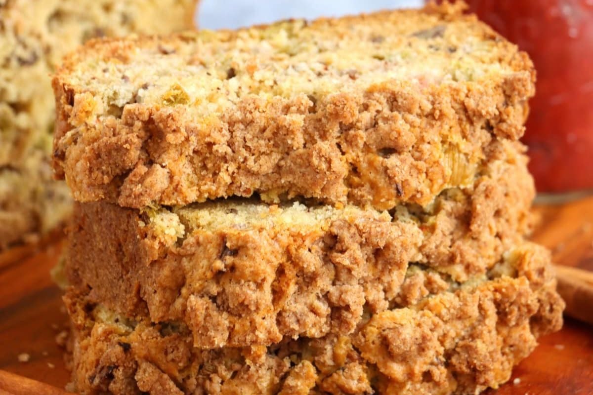 A close-up view of a crumbly loaf of bread with a coarse texture, perfect for rhubarb recipes, on a wooden surface.