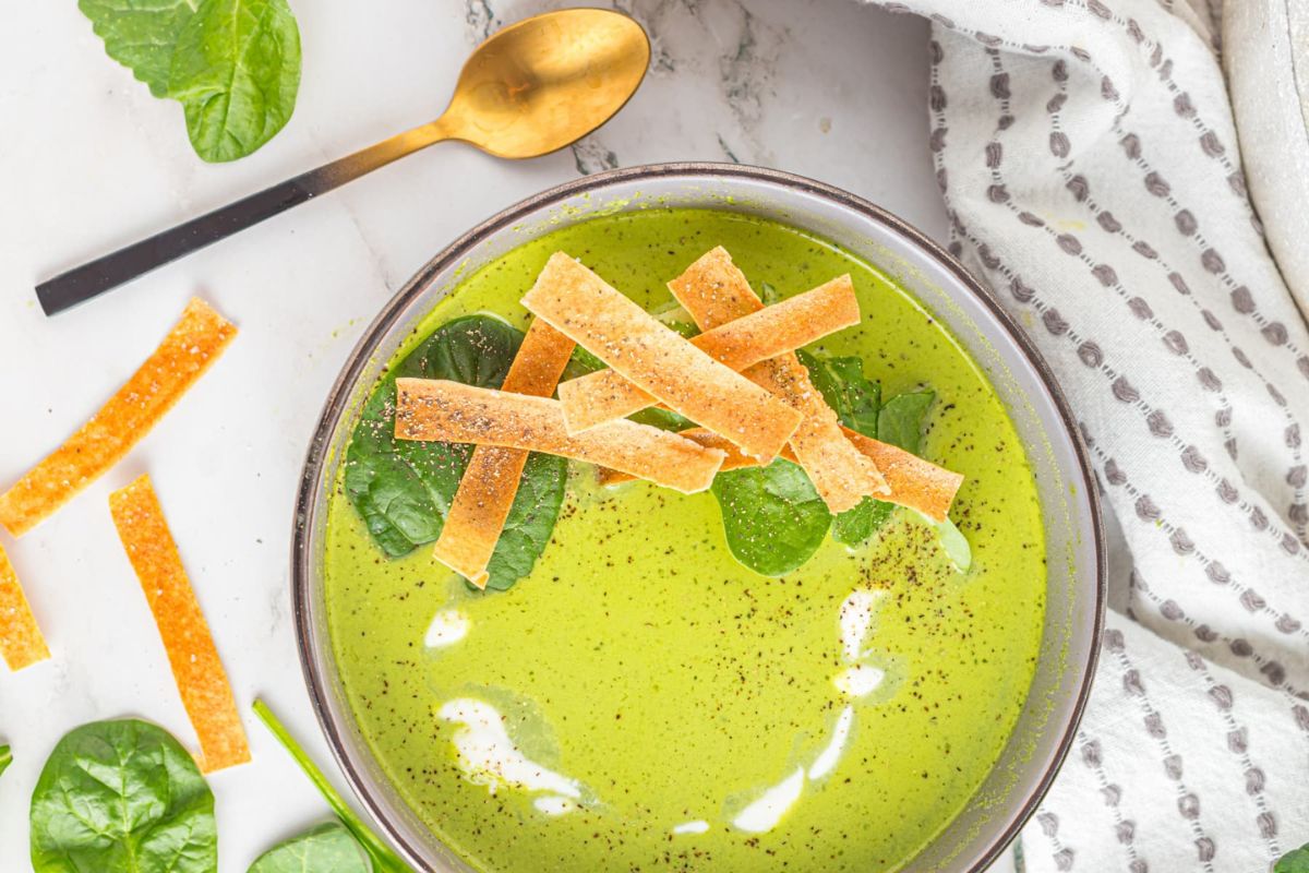 A bowl of spinach soup recipes with tortilla chips.