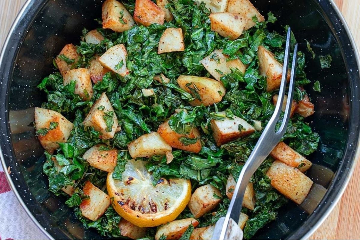 A bowl of kale and potatoes, perfect for potluck sides, with a fork.