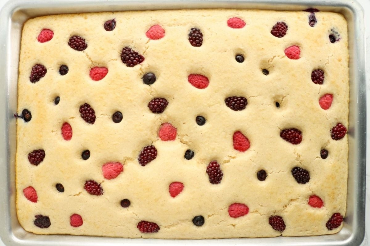A freshly baked sheet cake with raspberries and blackberries scattered on top for Father's Day breakfast.