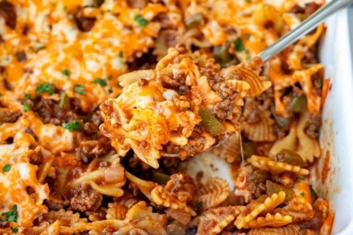 A spoonful of cheesy spring pasta casserole in a white dish.