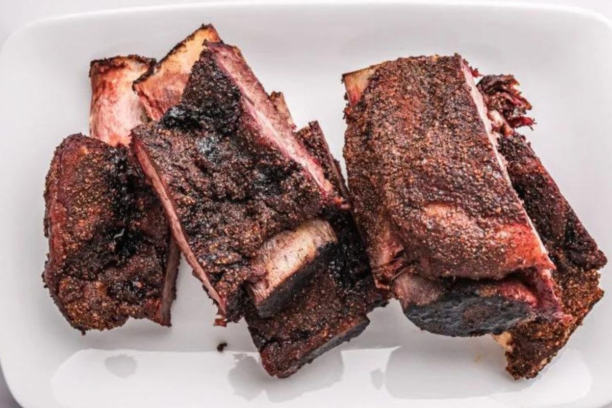Easy rib recipes: Sliced barbecued pork ribs on a white plate.