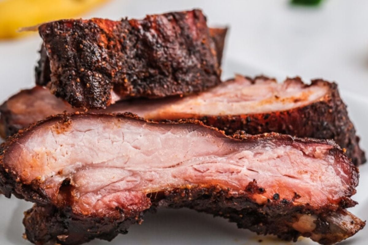 Slices of smoked brisket showing a smoke ring and charred crust, perfect for easy rib recipes.