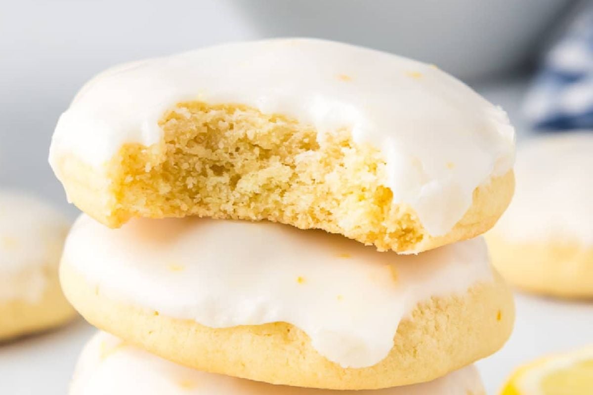 Iced lemon Easter cookies with one cookie partially broken to show the texture inside.