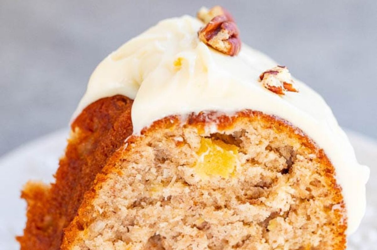 A close-up of a slice of carrot cake with cream cheese frosting and chopped nuts, perfect for Easter.