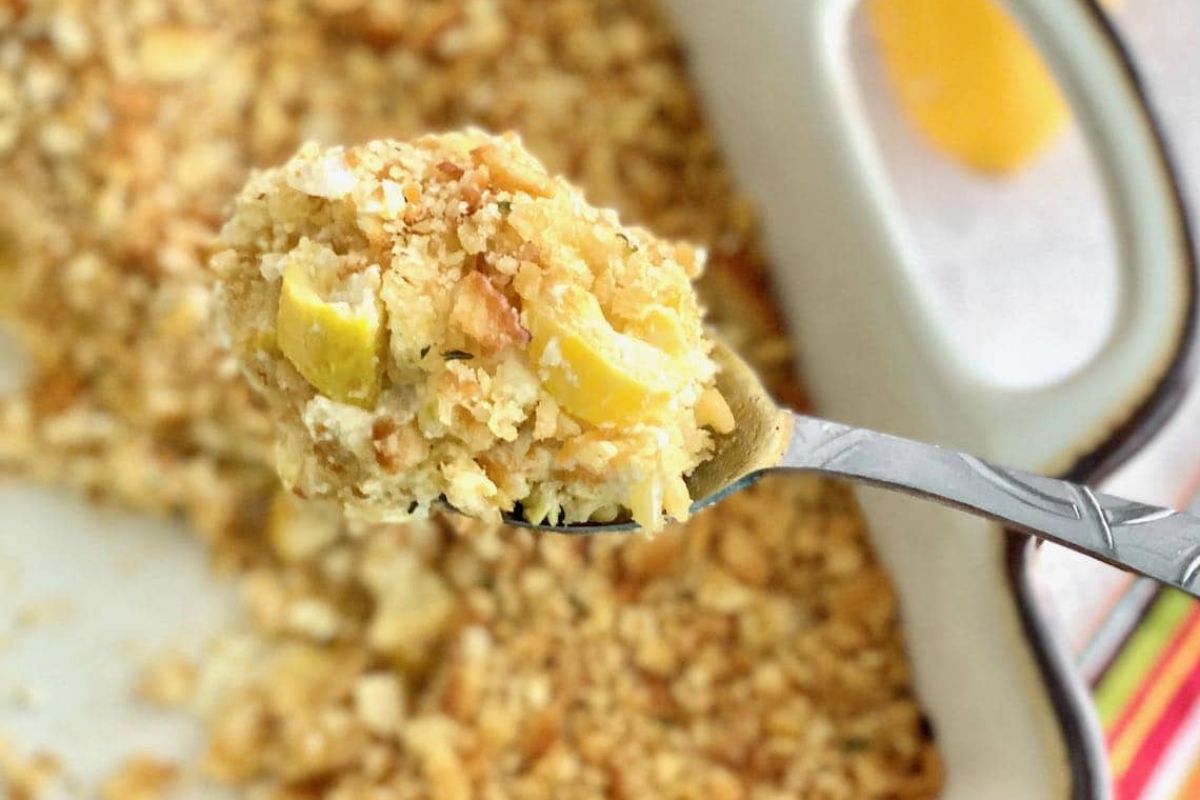 A spoonful of Easter sides casserole with visible egg pieces, topped with a crispy breadcrumb layer.