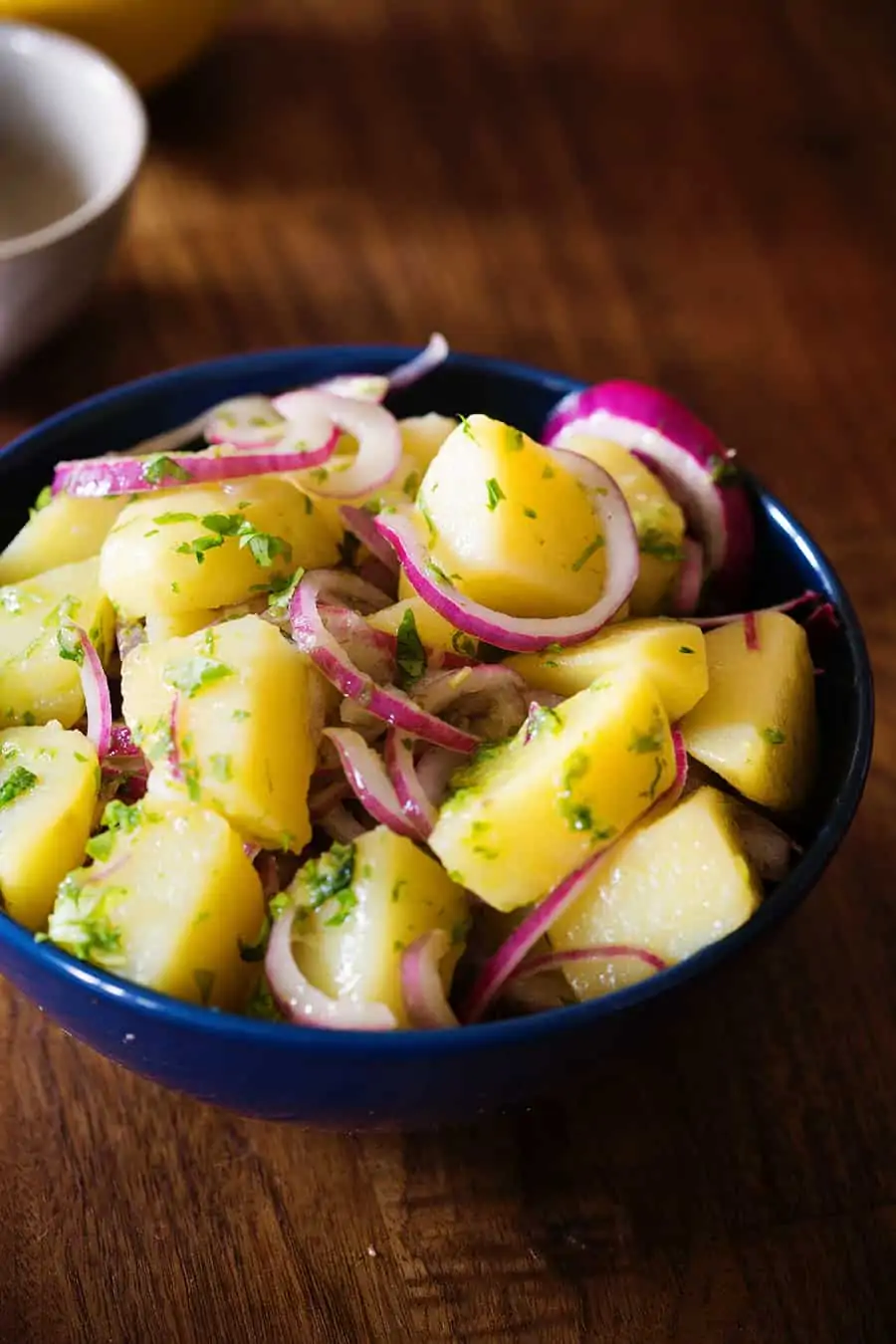 Italian potato salad on a deep blue bowl.
