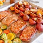 A tray of sheet pan honey garlic pork chops and vegetables, perfect for a quick sheet pan recipe.